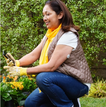 Woman checking her phone while gardening
