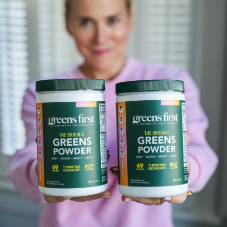 Woman holding canisters of Greens First Powder