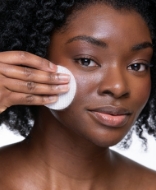 Woman applying cotton pad to face