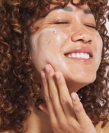 Woman applying Jan Marini mask to face