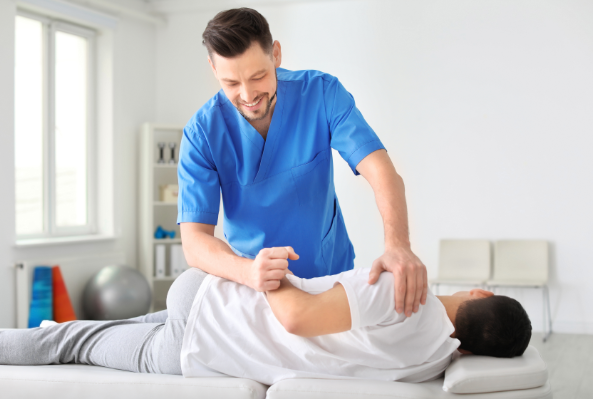 Physical Therapist adjusting patient on table
