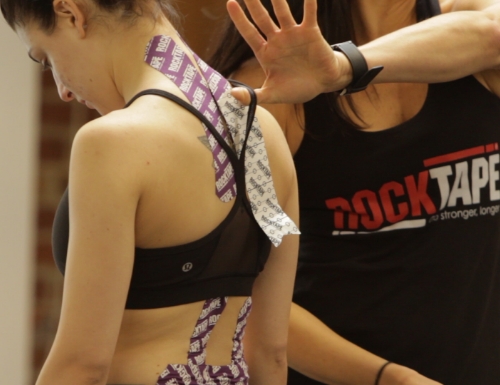 Woman applying RockTape during a FMT course.